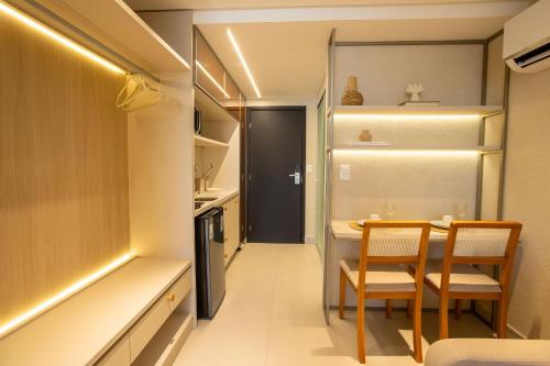a small kitchen and dining room with a table and chairs at Alta Garden Housi João Pessoa by Carpediem in João Pessoa