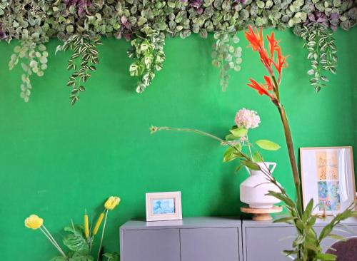a green wall with flowers on top of a cabinet at Living is Easy in Lopud Island