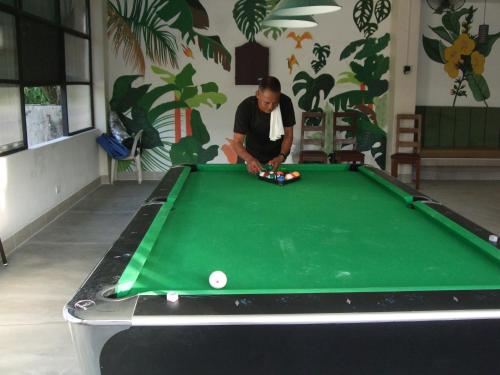 a man playing pool on a green pool table at Calicoan Villa in Sarog