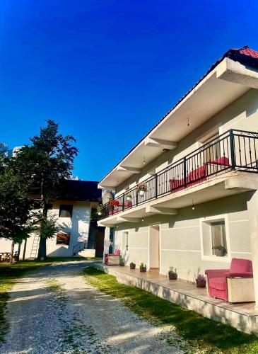 an apartment building with a balcony and a dirt road at Lazer Çardaku Guest House in Valbonë