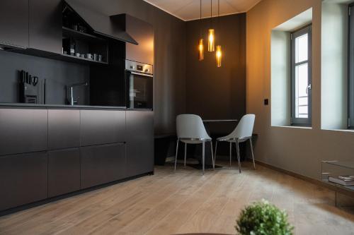 a kitchen with two white chairs and a table at KODERLE SUITE K4 Zampa D Orso in Brunico