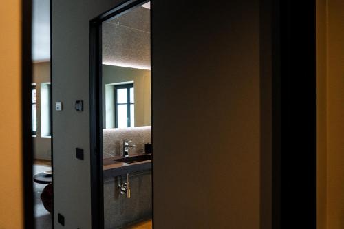 a mirror reflection of a bathroom with a sink at KODERLE SUITE K4 Zampa D Orso in Brunico