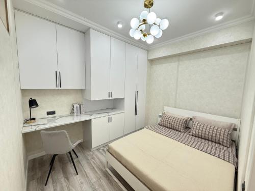 a small bedroom with a bed and a desk at NOVA apartment BayTash Tower near TSUM and GUM in Bishkek