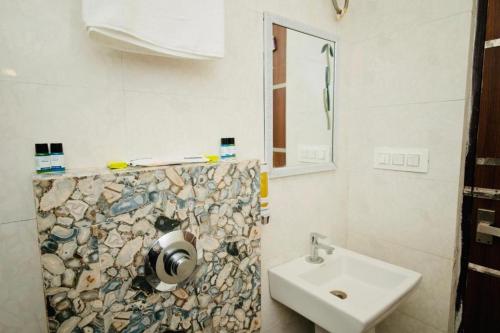 a white bathroom with a sink and a mirror at Golden Temple Paradise Stays in Amritsar