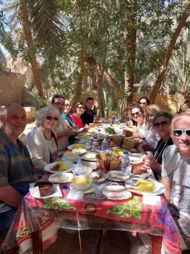 a group of people sitting around a table with food at New star hotel in Siwa