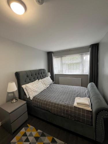 a bedroom with a bed and a window at Mona's Home in Dagenham