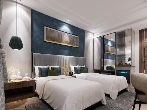 two beds in a bedroom with a blue wall at Solace Suites Hotel & Banquets in Barog