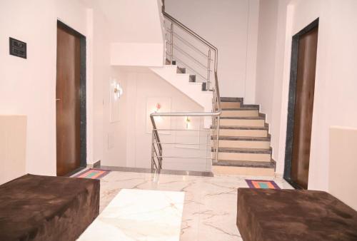 a staircase in a white room with a marble floor at Twilight Stays ll R Villa 3BHK ll Swimming Pool ll AC ll BBQ in Lonavala
