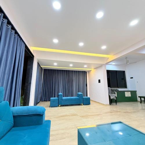 a waiting room with blue chairs and a screen at Twilight Stays ll R Villa 3BHK ll Swimming Pool ll AC ll BBQ in Lonavala