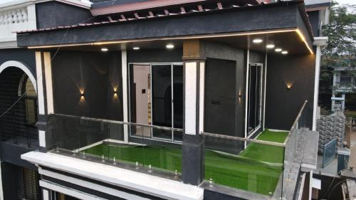 a house with a green lawn on the balcony at Twilight Stays ll R Villa 3BHK ll Swimming Pool ll AC ll BBQ in Lonavala