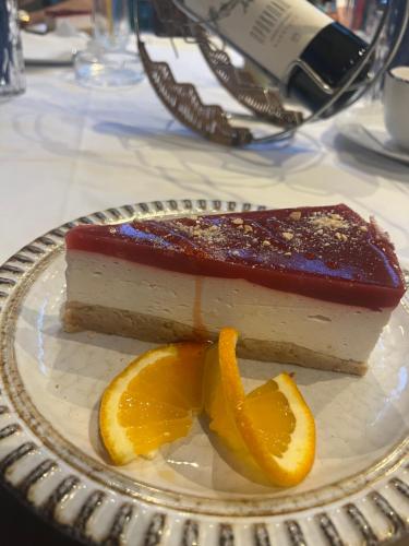 a piece of cake on a plate with an orange slice at Guesthouse Vladimir & Ana in Pančevo