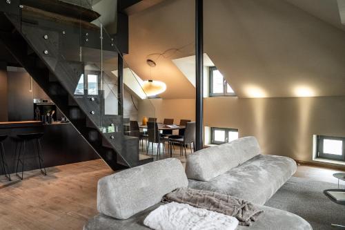 a living room with a couch and a staircase at KODERLE SUITE K5 Stella Alpina in Brunico