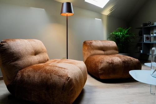 two ottoman chairs and a lamp in a room at KODERLE SUITE K5 Stella Alpina in Brunico