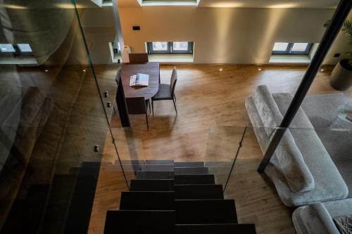 a room with a table and chairs and a staircase at KODERLE SUITE K5 Stella Alpina in Brunico