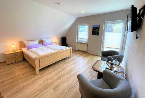 a bedroom with a bed and a couch and a chair at Beilsteiner Gästehaus in Beilstein