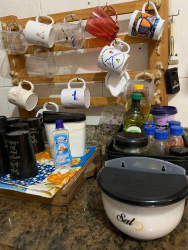 a kitchen counter with a toilet and some pots and pans at Hostel Casa Jambo Guaruja in Guarujá