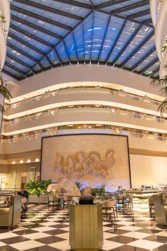 a large screen in a large room with tables and chairs at Taj Deccan in Hyderabad