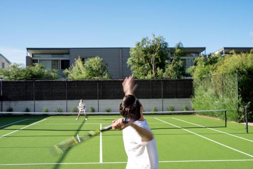 two women playing tennis on a tennis court at Smiths Beach Resort in Yallingup