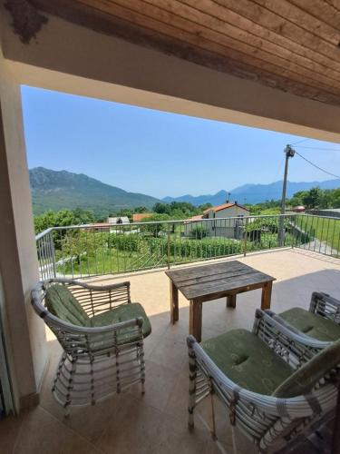 a patio with a wooden table and chairs and a view at Village house Vukmanovic in Bukovik
