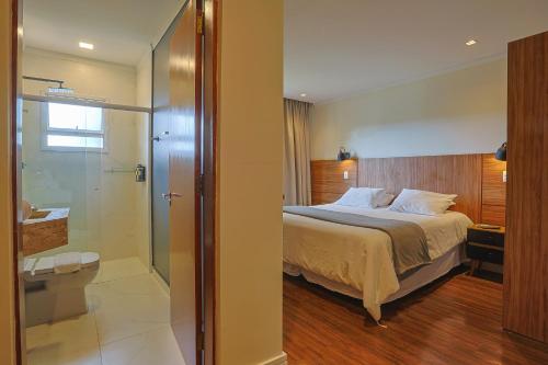 a bedroom with a bed and a glass shower at Ti Voglio Bene in Campos do Jordão