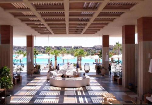 eine Lobby eines Resorts mit Blick auf das Wasser in der Unterkunft Swanlake Lagoon Luxury Villa in Zāwiyat al ‘Awwāmah