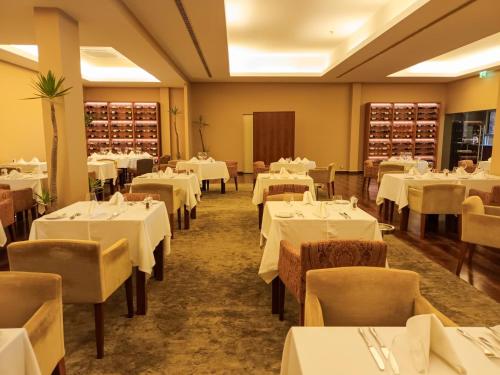 a dining room with white tables and chairs at AP Lago Montargil - Conference & SPA in Montargil