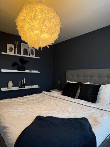 a bedroom with a large bed and a yellow chandelier at Familjevänligt radhus in Arlöv