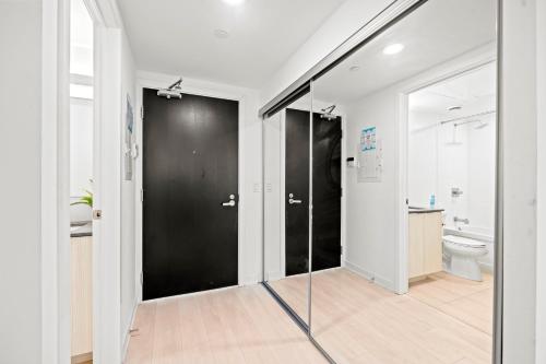 a bathroom with a black door and a toilet at New Modern 1Bd & Den in Downtown Toronto in Toronto