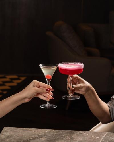two people holding up two cocktails in their hands at Taj Deccan in Hyderabad