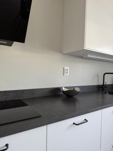a kitchen with white cabinets and a bowl on the counter at Familjevänligt radhus in Arlöv