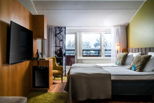 a hotel room with a bed and a flat screen tv at Break Sokos Hotel Levi in Levi
