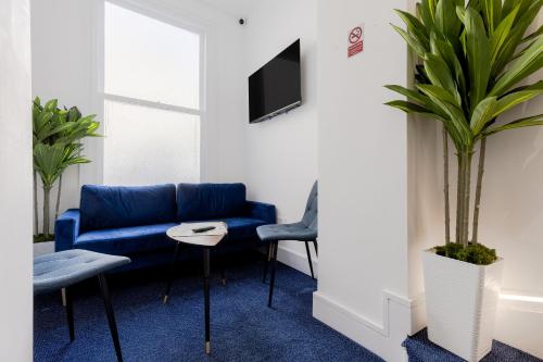 a living room with a blue couch and a table at Upper Berkeley Hotel in London