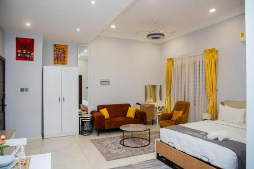 a bedroom with a bed and a living room at D'Magnolia Luxury Apartments in Ogbojo