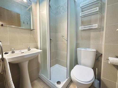 a bathroom with a shower and a toilet and a sink at Apartamentos Turísticos Santo Rostro in Chipiona