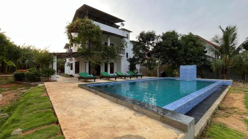 ein Swimmingpool vor einem Haus in der Unterkunft Wind Haven Yala in Tissamaharama