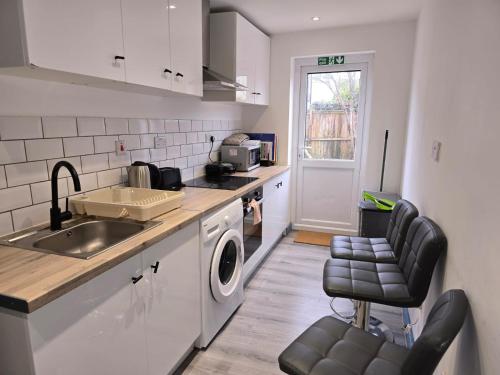 een keuken met een spoelbak en een wasmachine bij Coniston House in Freston