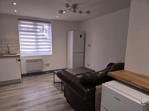 een woonkamer met een bank en een koelkast bij Coniston House in Freston