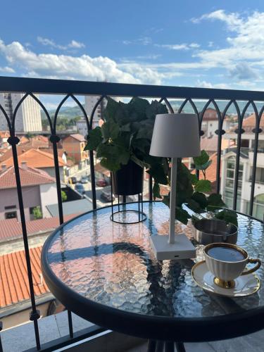 a glass table on a balcony with a view of a city at Star apartman 3 in Novi Pazar
