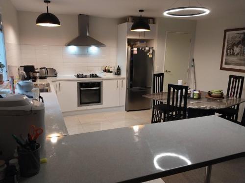 a kitchen with a refrigerator and a table with chairs at Coastal Retreat in Wellington - Perfect for Quick Stays in Wellington