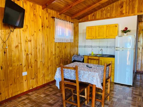 a kitchen with a table and a white refrigerator at Portal del sol in Puerto Iguazú