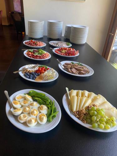 a black table with plates of food on it at Willa Zameczek in Polanica-Zdrój