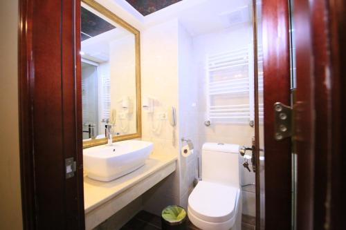a bathroom with a sink and a toilet and a mirror at Borjomi Palace Health & Spa Center in Borjomi