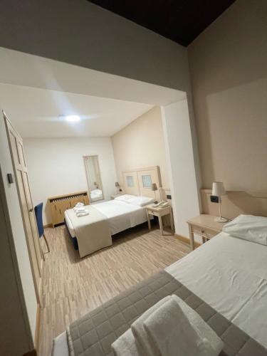 a hotel room with two beds and a desk at Hotel Ristorante Franca in Tovo di Sant'Agata
