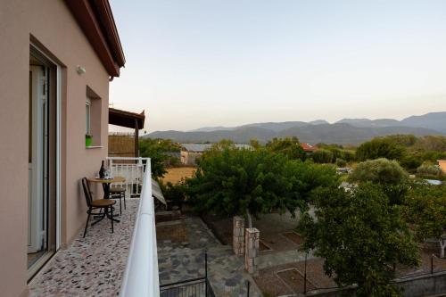 a balcony of a house with a table and chairs at Valira Stathmos Home, Rustic Charm Cottage w Views in Valíra