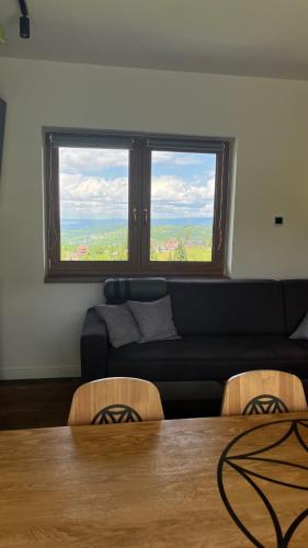 a living room with a couch and a table and a window at Góralski Reset in Gliczarów Górny