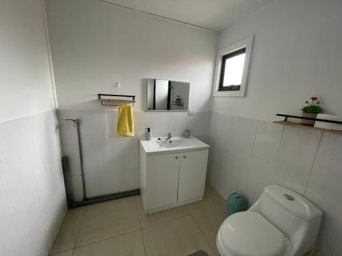 ein Badezimmer mit Toilette und Waschbecken in der Unterkunft Cabaña El Retiro in Lebu