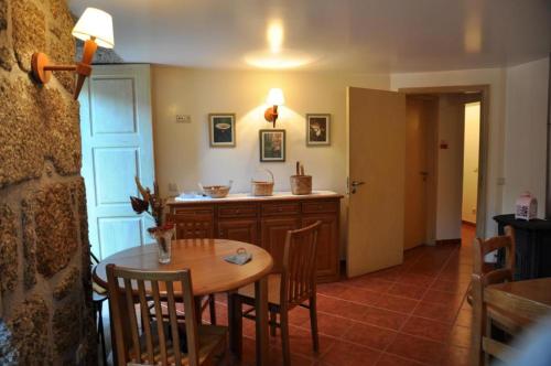 a dining room with a table and a kitchen at casa do meio da vila suites in Loriga