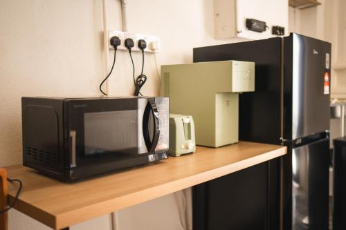 a microwave sitting on a counter next to a refrigerator at Carnarvon 73 in George Town