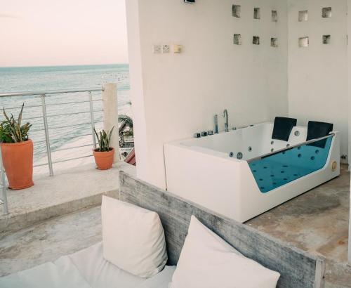 a bath tub in a room with a view of the ocean at ZAN Tropical Island in Bwejuu