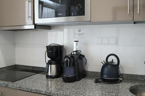 a kitchen counter with a coffee maker and a blender at Cagaréus in Aveiro